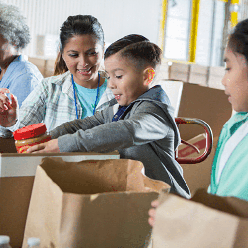A woman and two kids assisting a couple with boxes.