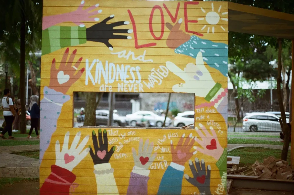 Vibrant mural of hands and hearts painted on a wall, symbolizing unity and love in a beautiful display of colors.